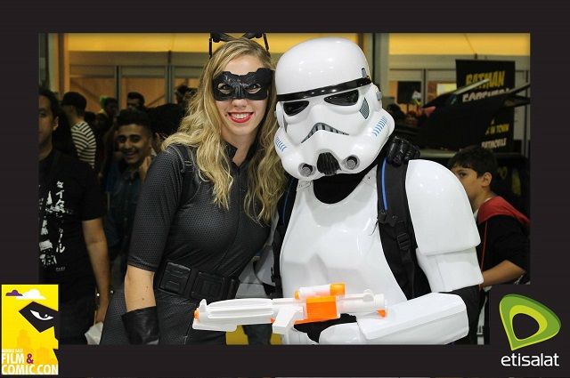 People dressed as cat woman and a storm trooper in photo booth picture from comic con