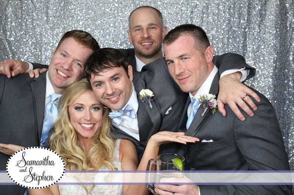 bride and groomsmen pose in photo booth